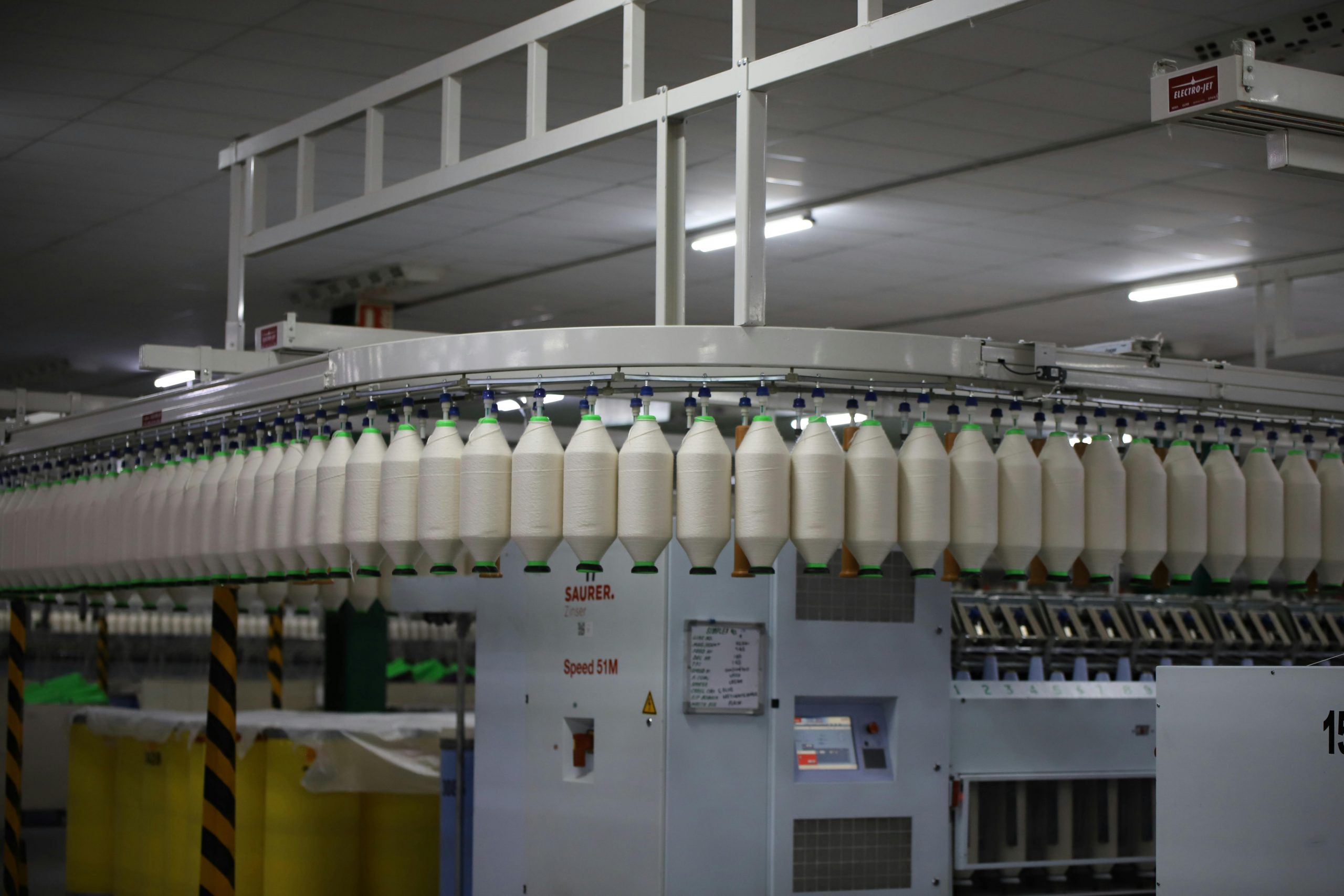 Conveyor belt with multiple pieces of yarn being produced.